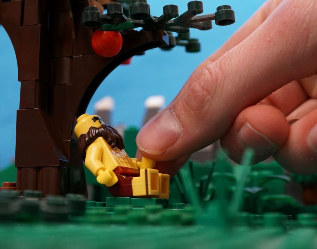 Eine Legofigur wird von einer Hand bewegt